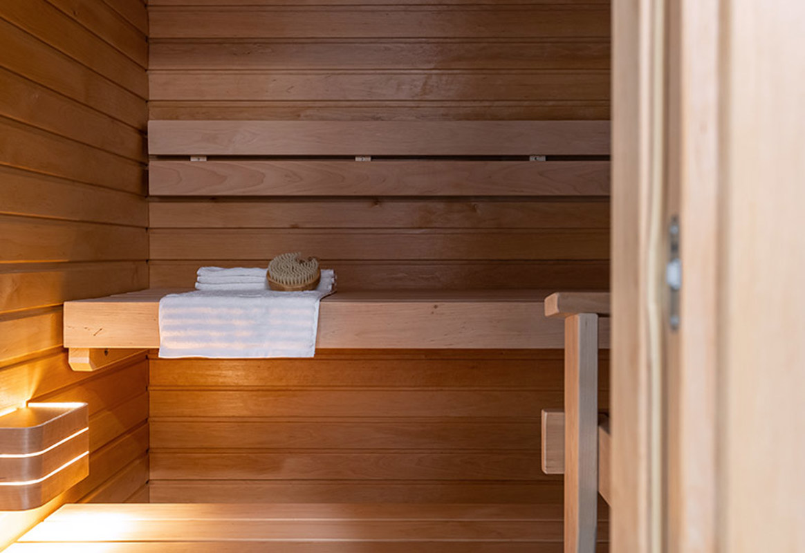 Sauna, jonka lauteilla on pesuharja ja pyyhe.