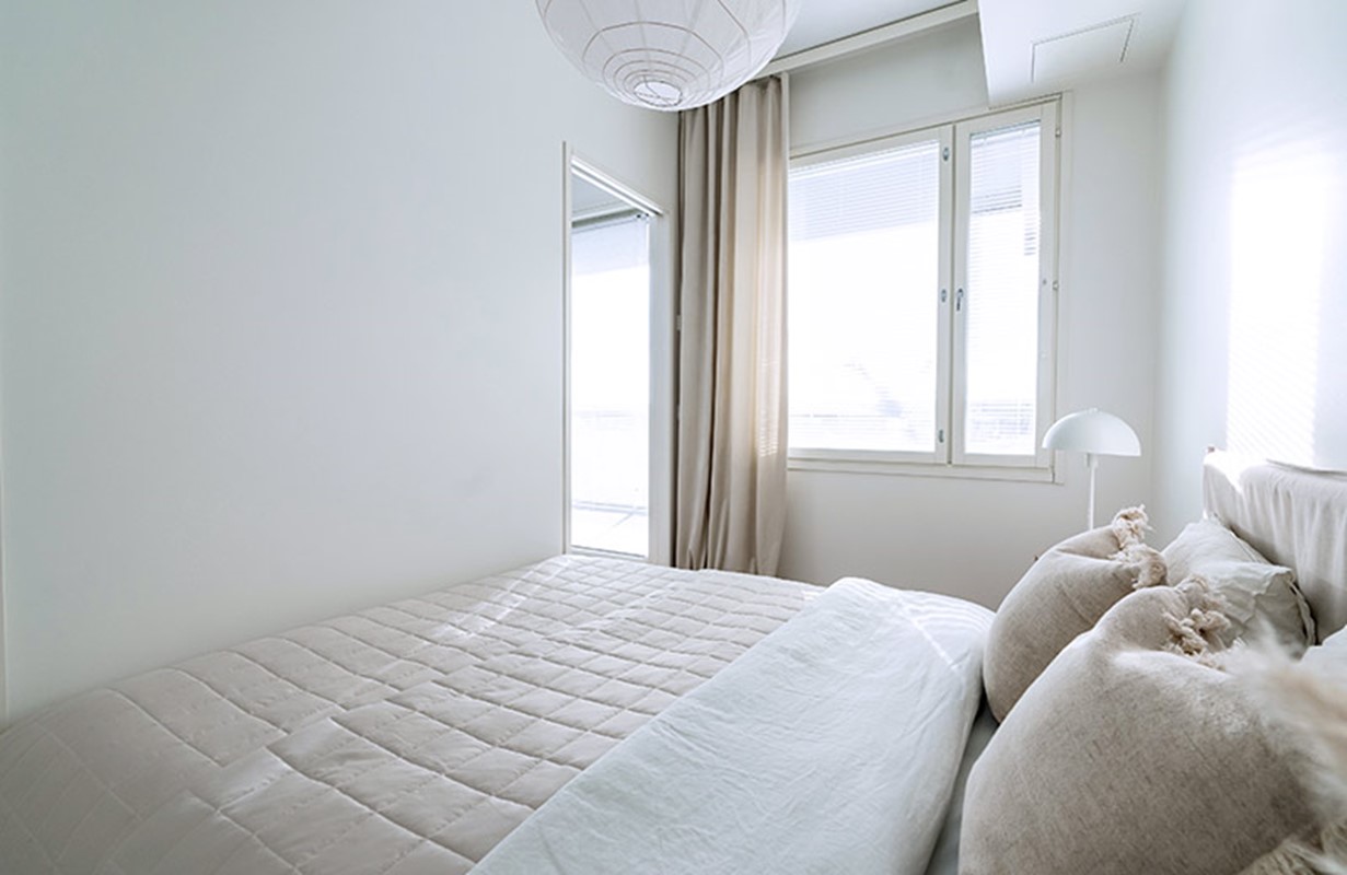 Vaalea skandinaavisesti kalustettu makuuhuone Hartelan rakentamassa uudessa kerrostalossa.
